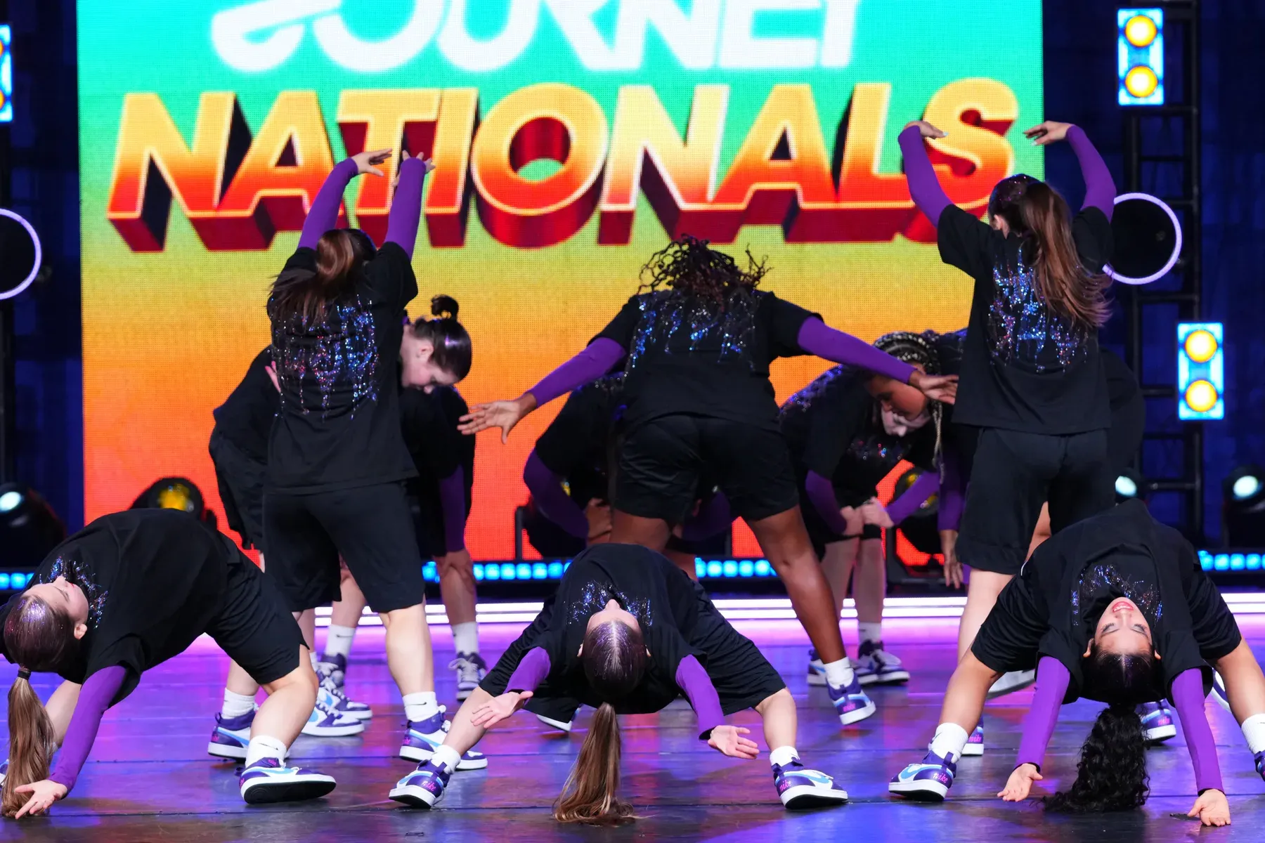 The C3 team bent low in unison in front of the Journey Nationals screen