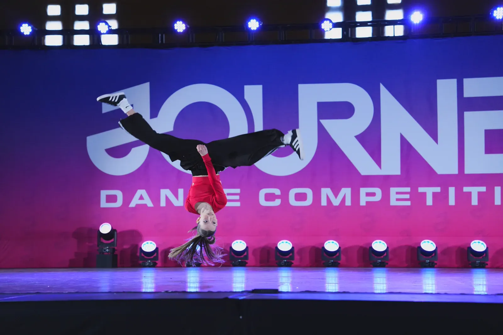 A C3 dancer captured upside down mid-air during a competition routine