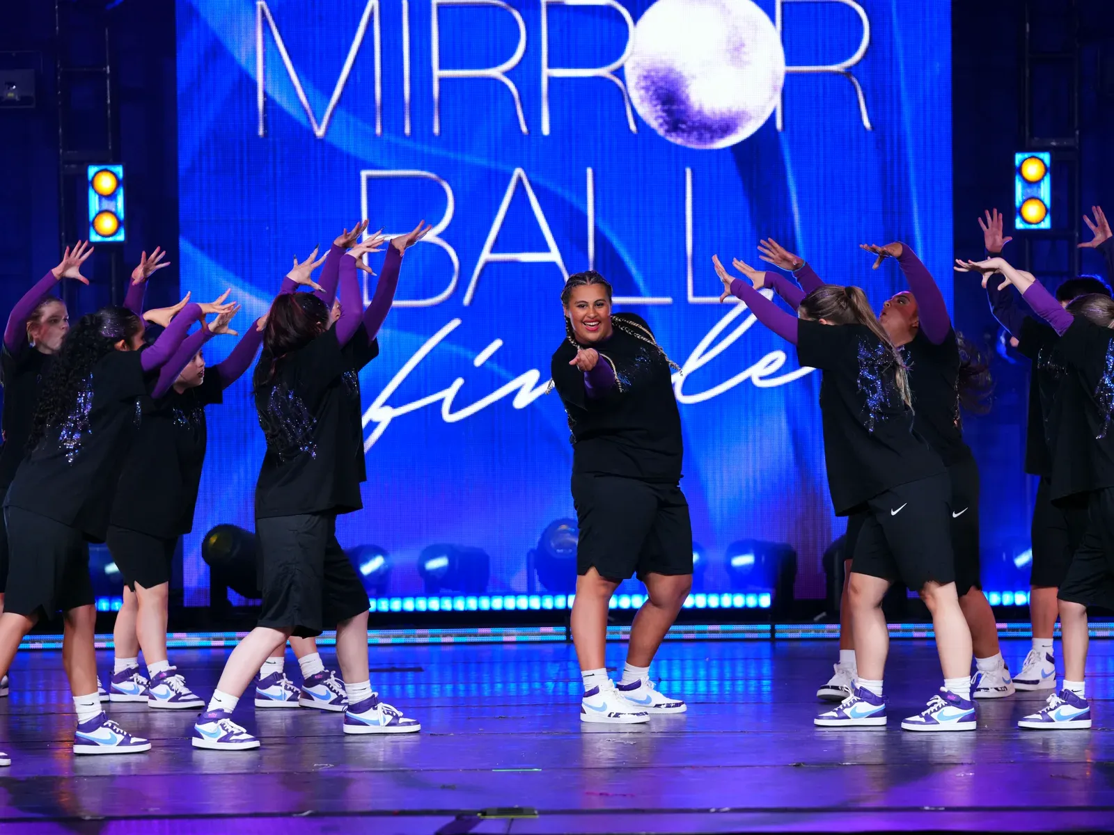 The C3 team mid-routine on the Mirror Ball Finale stage, arms raised together