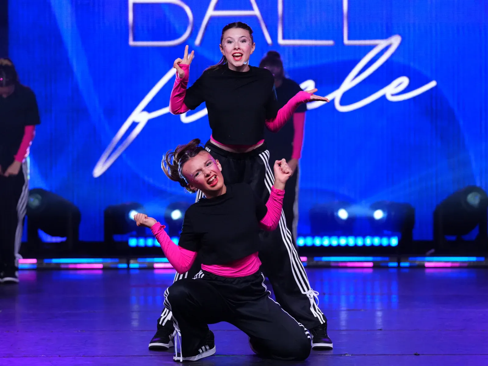 Two C3 dancers mugging for the crowd mid-routine under the competition lights